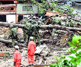 Japans Self-Defence Force members and fire fighters search for survivors in the rubble in a mud-ridden residential area following a massive landslide in Hiroshima on Friday.