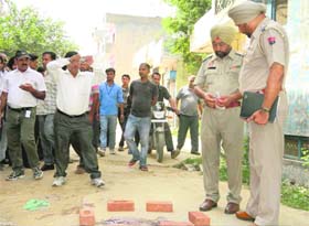 Police officials inspect the crime scene at Bhagat Singh Nagar in Dera Bassi on Saturday.