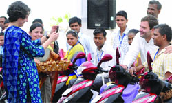 Priyanka Gandhi Vadra clicks a photo of Congress vice-president and trustee of the Rajiv Gandhi Foundation, Rahul Gandhi, sitting along with the differently abled during a function to distribute the keys of three-wheeler scooters in New Delhi on Saturday. Tribune Photo: Mukesh Aggarwal