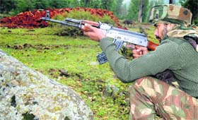 An Army soldier takes position near an encounter site in Baramulla district on Saturday.