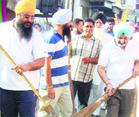 Former DGP Paramdip Gill cleaning streets in Moga city on Saturday. Tribune Photo