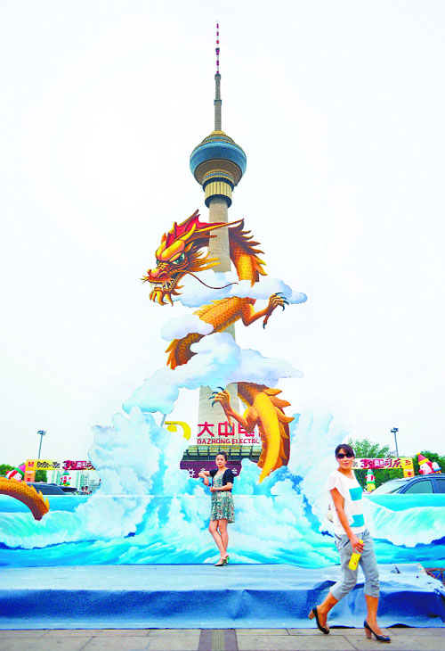 Visitors pose in front of a "3D painting" during a Magic Art Special exhibition outside a television tower in Beijing.