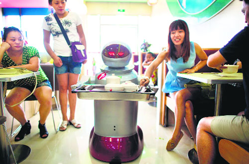 A robot carrying food to customers in a restaurant in Kunshan. It’s more teatime than Terminator — a restaurant in China is electrifying customers by using more than a dozen robots to cook and deliver food