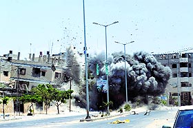 Smoke and flames are seen during bombing caused by an Israeli air strike on a house in Gaza City on Saturday. 