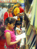 Book lovers at a stall during the 20th Delhi Book Fair-2014 at Pragati Maidan in New Delhi on Sunday