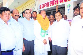 INLD nominee Makhan Lal Singla with traders at the grain market in Sirsa on Saturday