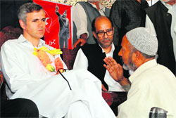Chief Minister Omar Abdullah listens to a National Conference worker during a public rally in Srinagar on Sunday. Tribune Photo: Amin War