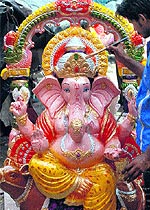 An artist gives final touches to a statue of Lord Ganesha for the upcoming Ganesh Chaturthi festival in Jalandhar on Sunday