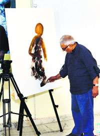 Renowned artist Sidhartha paints on a canvas during an event at the Bhutta Group of Colleges near Mandi Ahmedgarh. 