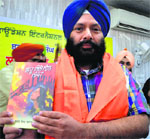 Barjinder Singh Brar shows his novel Lahu Bhijje Din-1947 after its release in Ludhiana.