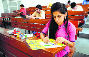 Students design posters during an intra-college talent hunt show at the Gujranwala Guru Nanak Institute of Management and Technology in Ludhiana.