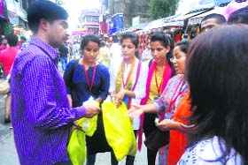 Members of the U Turn foundation distribute cloth bags at Paltan Bazaar in Dehradun on Sunday