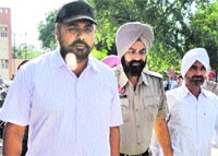 Gate Hakima police in charge Upkar Singh and Head Constable Satpal Singh being escorted to the court in Amritsar on Monday. Tribune photo