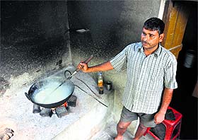 Garib Dass prepares milk cake in his shop at Chandu Chak village of the RS Pura sector in Jammu.