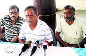 President of the National Mazdoor Conference Subash Shastri addresses a press conference in Jammu on Monday.