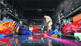 A firefighter douses flames at the factory unit where the fire broke out in Ludhiana on Monday