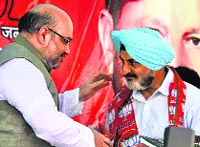 BJP president Amit Shah welcomes former DGP Paramdip Gill in the BJP at Kathua on Monday. Tribune photo