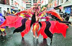 Fun on streets: A participant takes part in a wet Notting Hill Carnival in London on Monday. The Notting Hill Carnival is the biggest street carnival in Europe