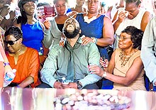 Michael Brown Sr cries as the casket is lowered into the ground at St. Peters Cemetery in St. Louis on Monday. Civil rights leaders joined family and friends to pay final respects to Michael Brown, the 18-year-old shot dead in a fatal encounter with police in Ferguson, US, on August 9