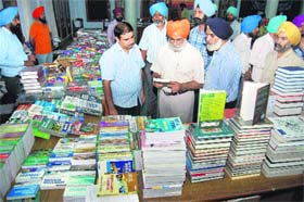 Khalsa College Governing Council honorary secretary Rajinder Mohan Singh Chhina along with the college staff looks at books during a book fair in Amritsar on Wednesday