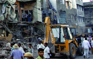 Workers of the Municipal Corporation raze shops in Azad Market for construction of the Rani Jhansi grade separator in New Delhi on Wednesday