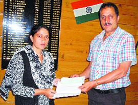 Kullu SP Surender Verma hands over a cheque to Kamla Devi on Wednesday.