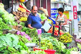 A vendor uses a polythene bag for packing vegetables in the Nai Basti area of Jammu