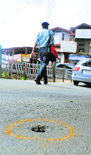 A policeman walks near the bullet mark on the road in Shimla on Thursday.