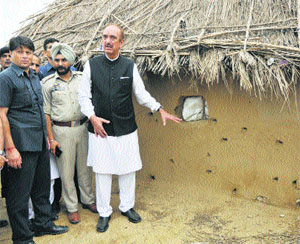 Congress leader Ghulam Nabi Azad points at shelling marks at Jeora Farm village in the R S Pura sector.