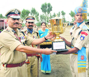 IG, CRPF, KS Bhandari gives an award to a recruit after the passing-out parade at Humhama on Thursday.