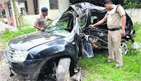 Police officials inspect a damaged car in Dehradun on Thursday.