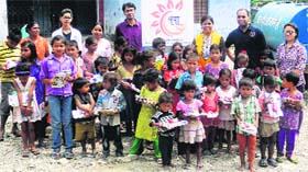 Members of NGO SHEWA distributed books among children at rain-hit Katbangla in Dehradun on Thursday.