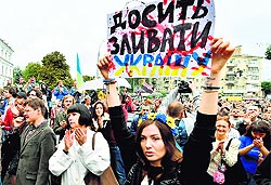 A girl holds a placard Enough surrender the Ukraine ! during the rally in front of the Ukrainian Defence Ministry in Kiev