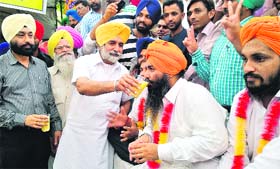 Sikander Singh Maluka, Rural Development and Panchayat Minister, Punjab, offers juice to a protesting member of the ETT Teachers Union after accepting their demands at Phase VIII, Mohali, on Friday.