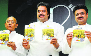 HJC chief Kuldeep Bishnoi, flanked by party leaders Dharampal Malik (left) and Chander Mohan, releases the manifesto in Chandigarh on Friday.