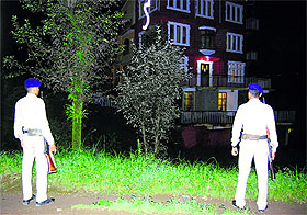 Security personnel stand in front of the Chabad House in Dharamkot.