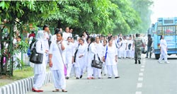 In the absence of a bus stop shed, girls wait on the roadside for buses outside Government College for Women, Gandhi Nagar, Jammu. Tribune photo: Anand Sharma