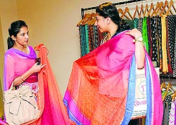 Visitors admire the saris at the exhibition