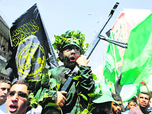 A boy holds a replica gun as Palestinians take part in a rally celebrating what they say was a victory by Palestinians in Gaza over Israel following a ceasefire, in Hebron on Friday.