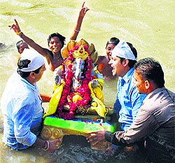 Devotees immerse Lord Ganeshas statue on the second day of the 10-day Ganesha festival in a river on the outskirts of Amritsar on Saturday