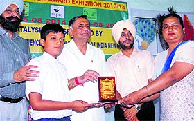 BJP MLA Manoranjan Kalia gives away prize to a student during the closing ceremony of a science exhibition in Jalandhar on Saturday.