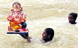 An idol of Lord Ganesha being immersed in Sirhind Canal