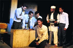 Artistes enact a scene from the play 'Zameen ka Sawal' at Natrang Theatre in Jammu on Sunday