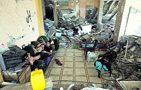 Palestinians lie on a sofa inside their destroyed house after returning home in eastern Gaza City on Sunday.