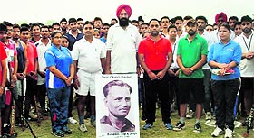 Students and staff members of Guru Kashi University pose with a picture of hockey legend Major Dhyan Chand before the starting of a match in Talwandi Sabo.