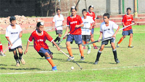 Players vie for the ball during a match of the 13th ONGC SN Vohra Memorial Hockey Tournament at the hockey stadium in Sector 18, Chandigarh, on Monday. 