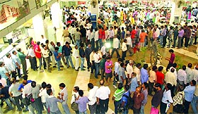 People queue up at Vikas Sadan to buy application forms for the flats in New Delhi on Monday. 