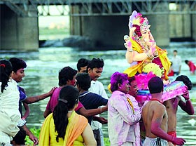 Devotees immerse an idol of Lord Ganesha into the Yamuna near ITO in New Delhi  on Monday.