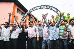 Members of the PHE Workers Welfare Association protest in Jammu on Monday