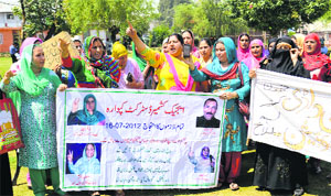 Demanding regularisation, anganwadi workers stage a protest in Srinagar on Monday.